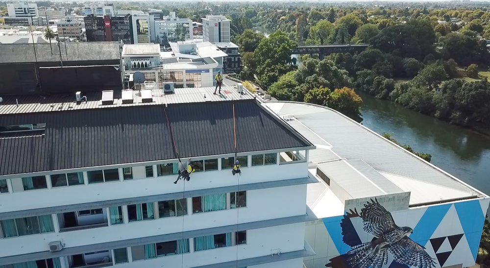 Industrial abseilers cleaning apartment building windows