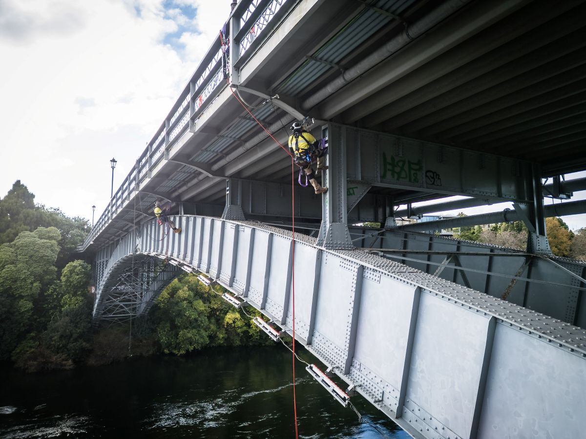 Connect Access rope access technicians performing bridge maintenance on the Anzac Parade Bridge in Hamilton using industrial abseiling methods over the Waikato River.