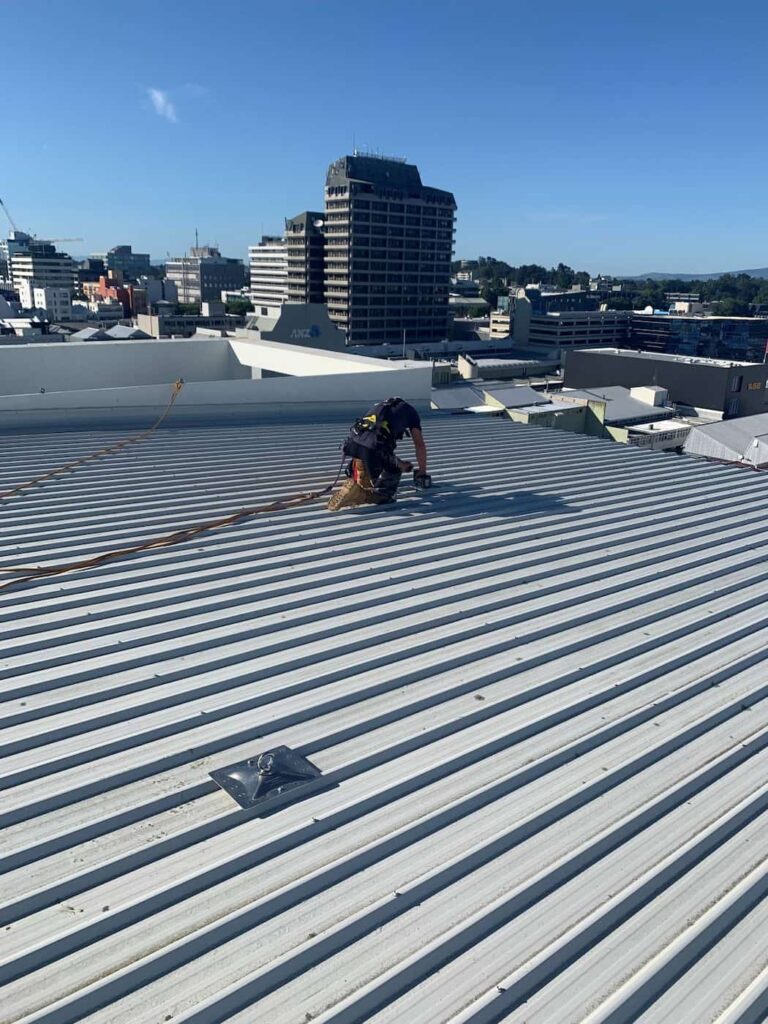 A rope access anchor is installed on a city building's roof by Connect Access